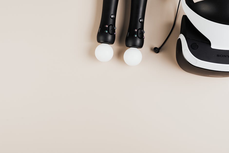 Top view of gaming controllers and VR headset on neutral background.