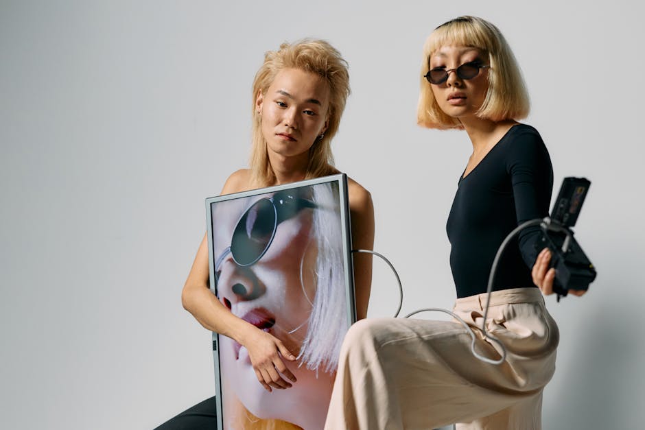 Chic editorial fashion shoot featuring stylish models with technology elements in a studio setting.