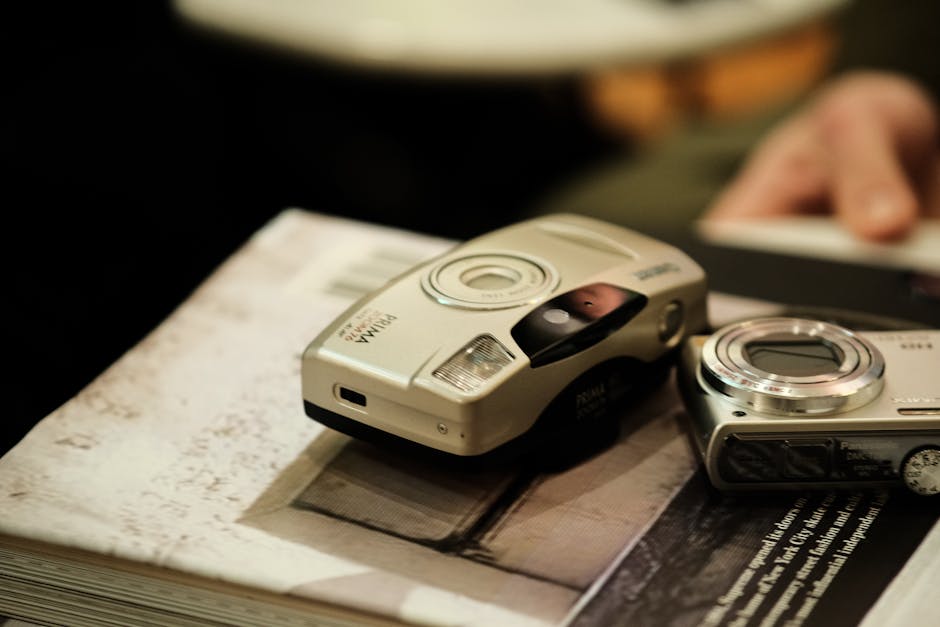 Close-up of vintage analog cameras resting on a photography book. Perfect for retro technology themes.
