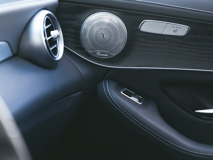 Close-up of a luxury car's sleek interior showcasing a premium speaker and air vent design.