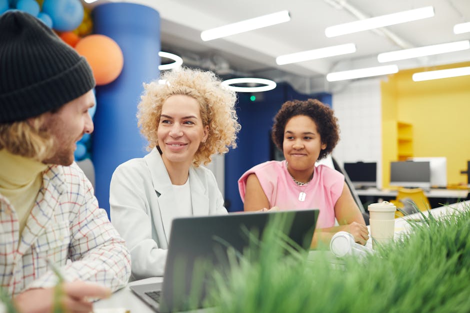 A group of colleagues engaged in a friendly discussion in a vibrant modern office setting.