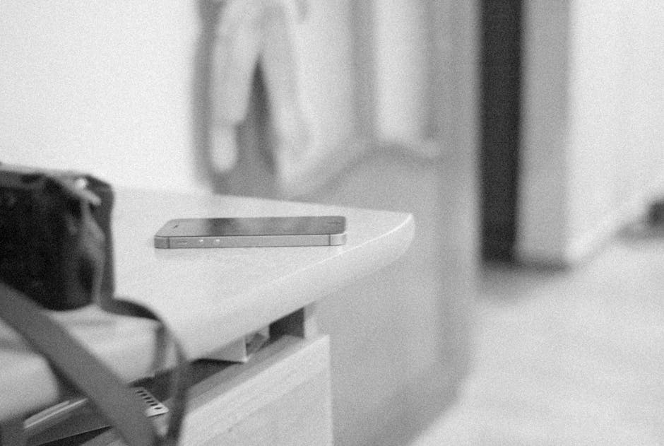 Black and white minimalism featuring a smartphone on a table indoors.