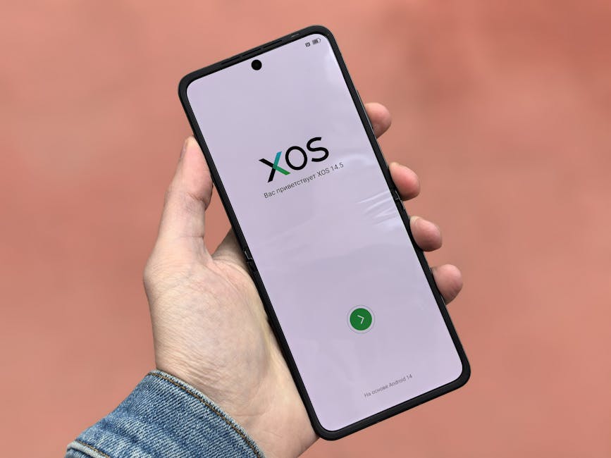 Close-up of a smartphone displaying the XOS 14.5 operating system interface in a hand.