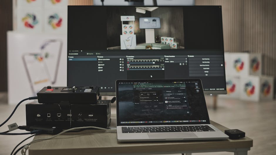 Multimedia setup featuring a laptop and a large monitor in a tech-savvy workspace.
